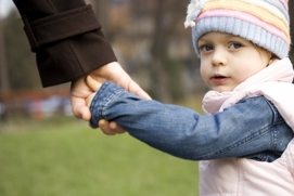 a young girl holding her parent's hand