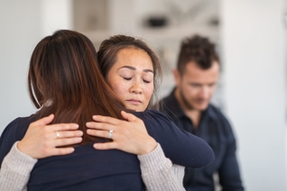 two women hugging and comforting each other