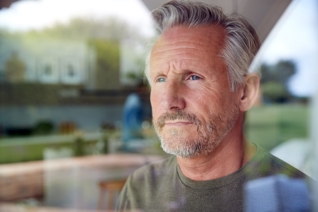 an older man looking out of the window