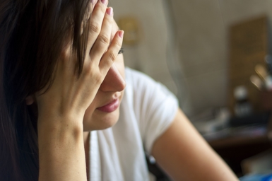 worried woman with head in hand worried woman with head in hand