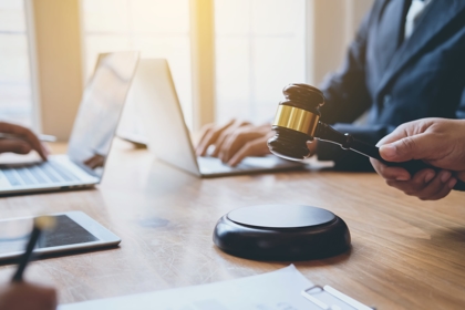 banging a gavel on a desk with laptops