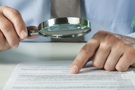 a man examining a document with a magnifying glass