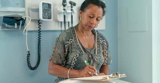 African American Woman in doctors office filling out paperwork