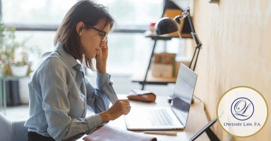 woman sitting at her desk looking at her laptop