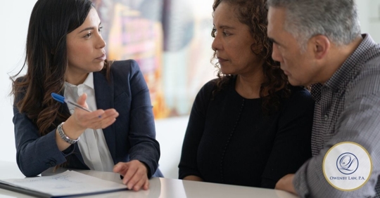 Husband and wife speaking to a professional woman in a blazer