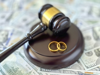 gavel and wedding rings on top of money