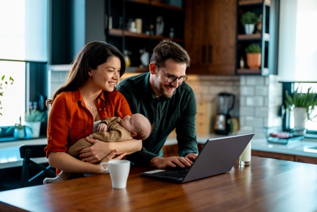 young family looking at laptop